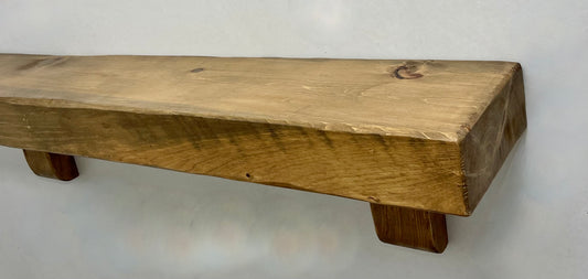 Reclaimed wood fireplace mantel with a distressed finish. Features natural knots and grain variations, adding rustic farmhouse character.